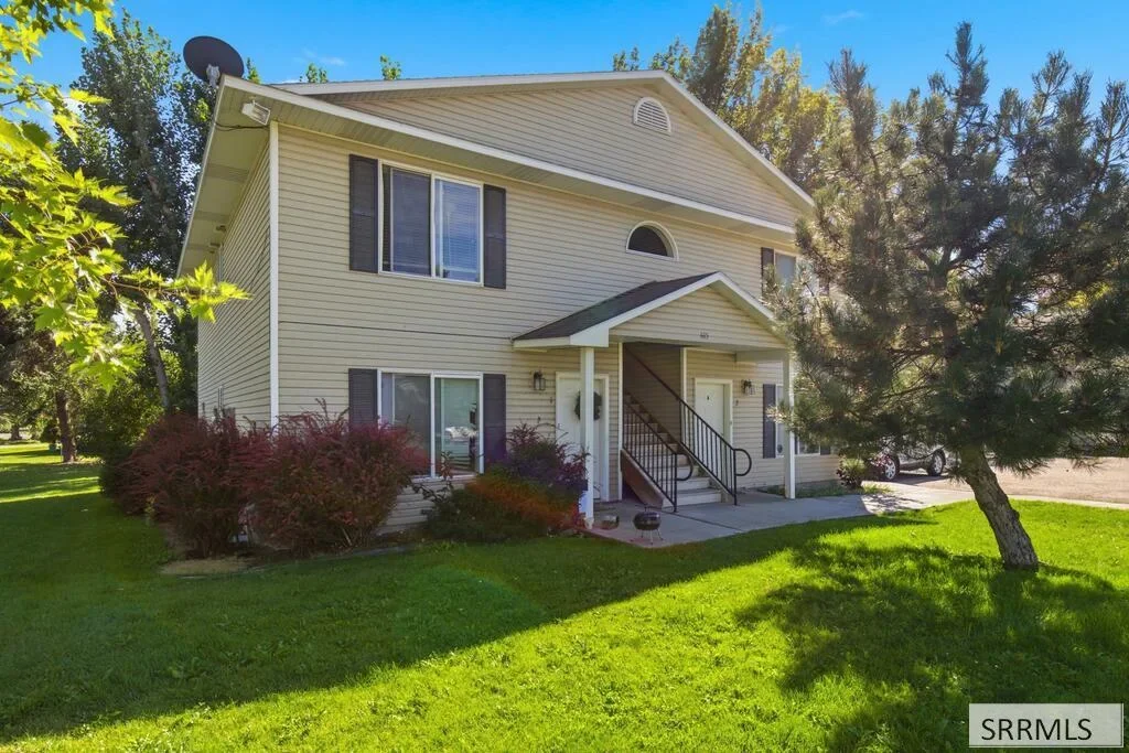 A two-story fourplex with landscaped beds near central Rexburg