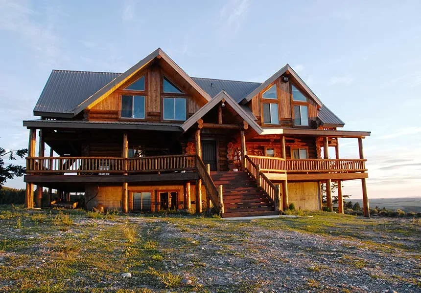 The hand-built log lodge Jeff and Alana Lerwill built above Newdale, Idaho, at dusk
