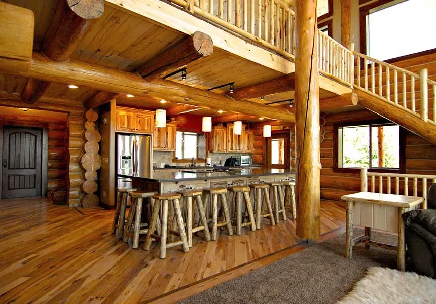 A vaulted log great room with a kitchen and loft