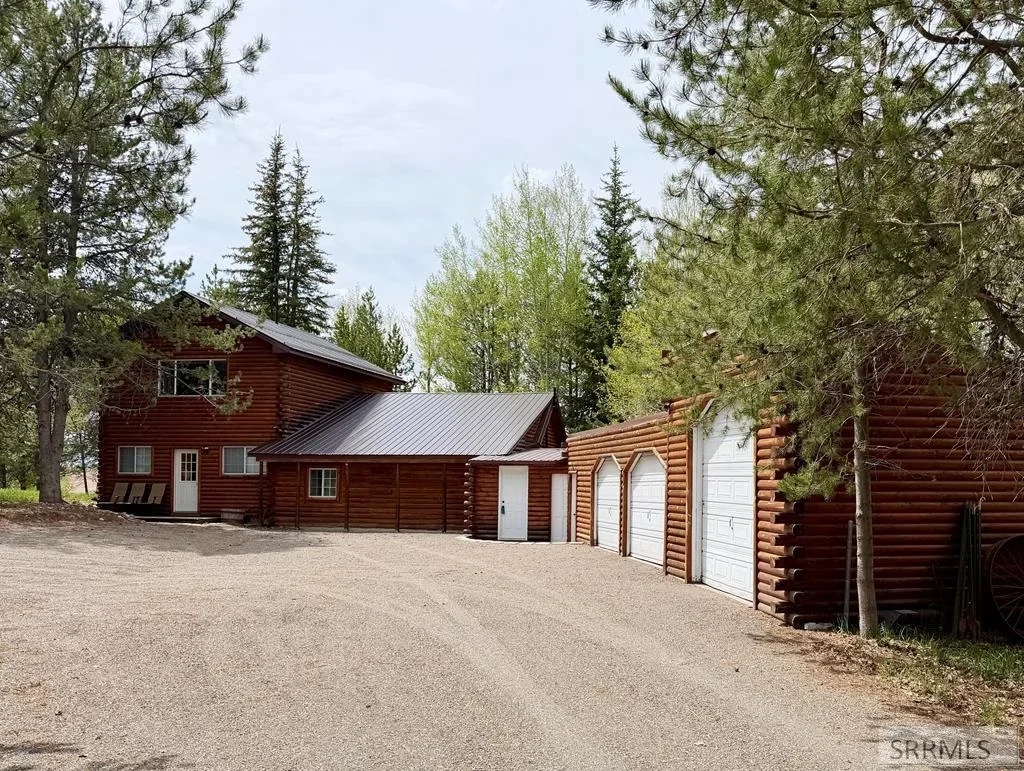 A log home and detached log garages among pines and aspens near Ashton, Idaho