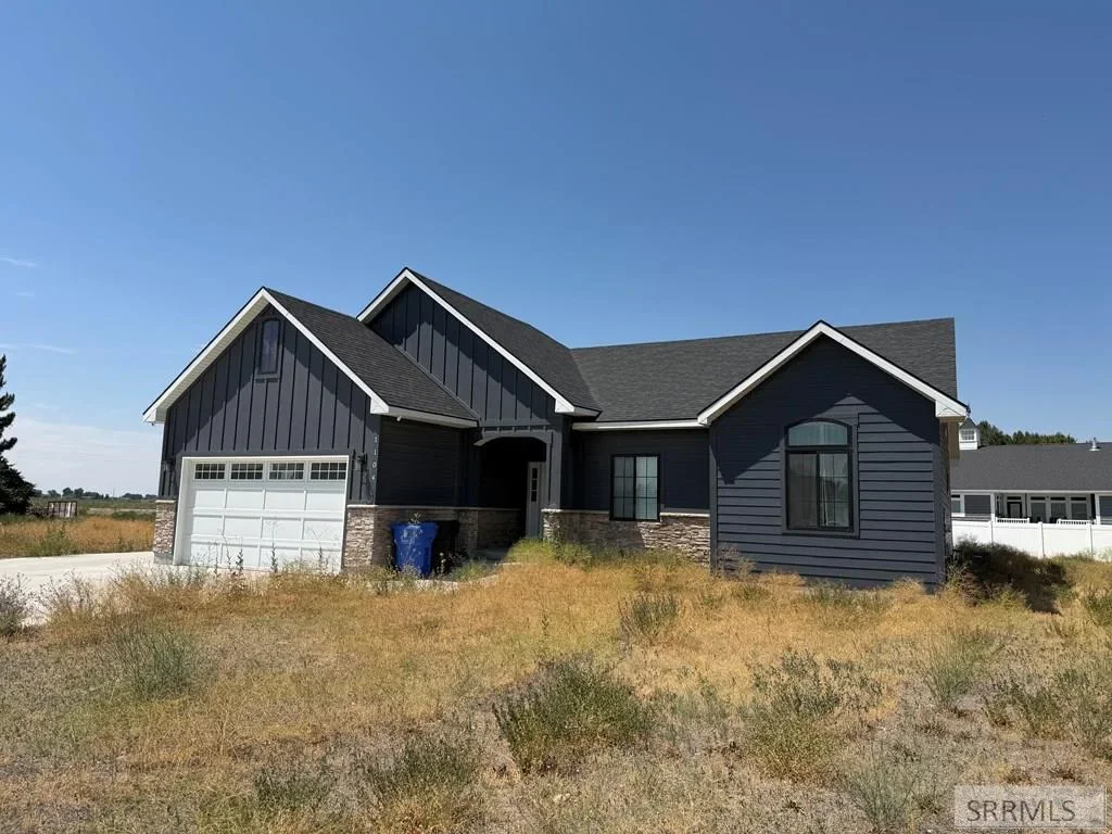 A modern board-and-batten home with a stone base and two-car garage in Rexburg